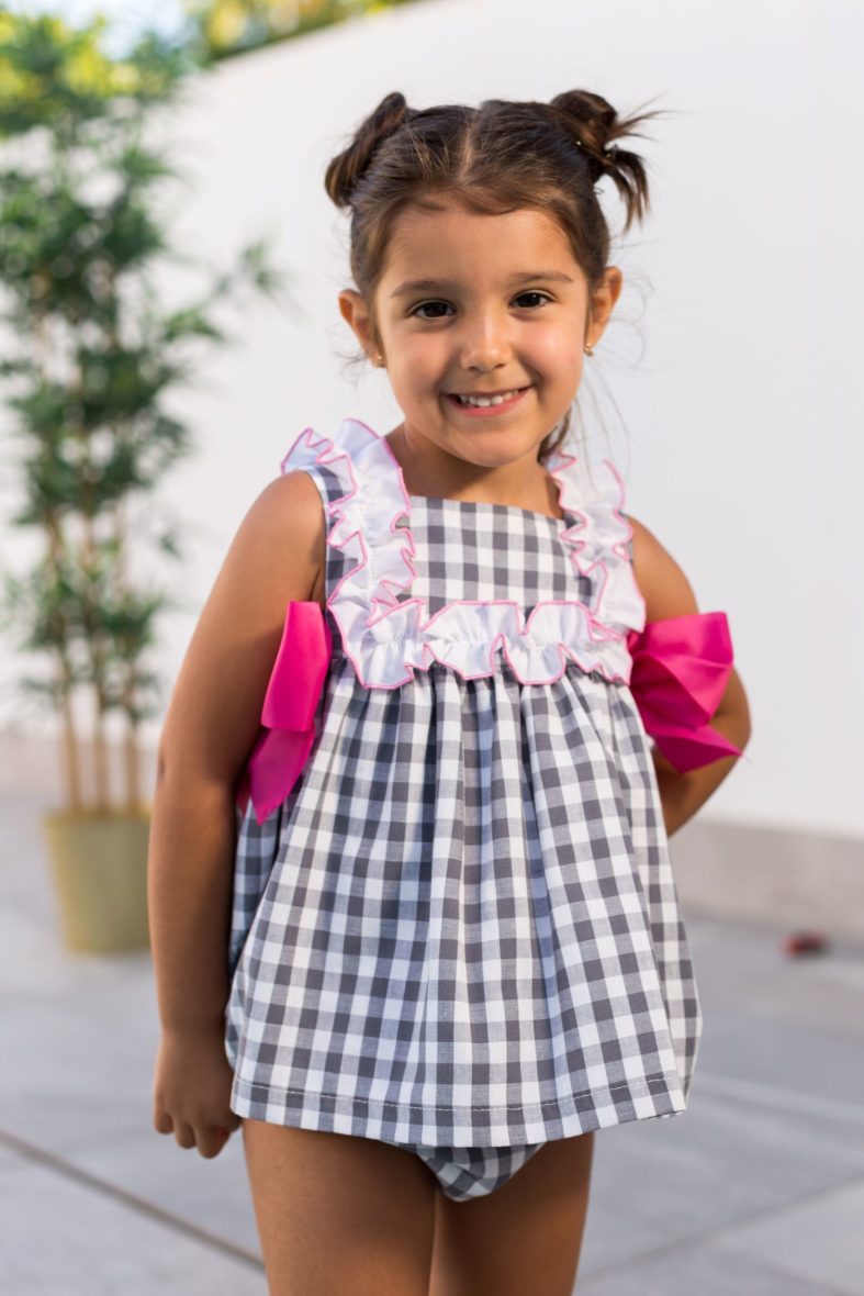 Jesusito con braguita niña de Mon Petit Bonbon a cuadros grises lazos fucsia Familia Foca
